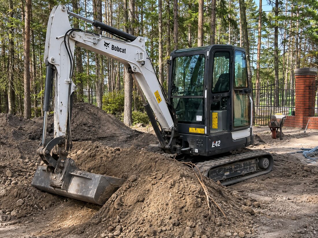 Minikoparka Bobcat przy pracach ziemnych i wykopie w ogrodzie